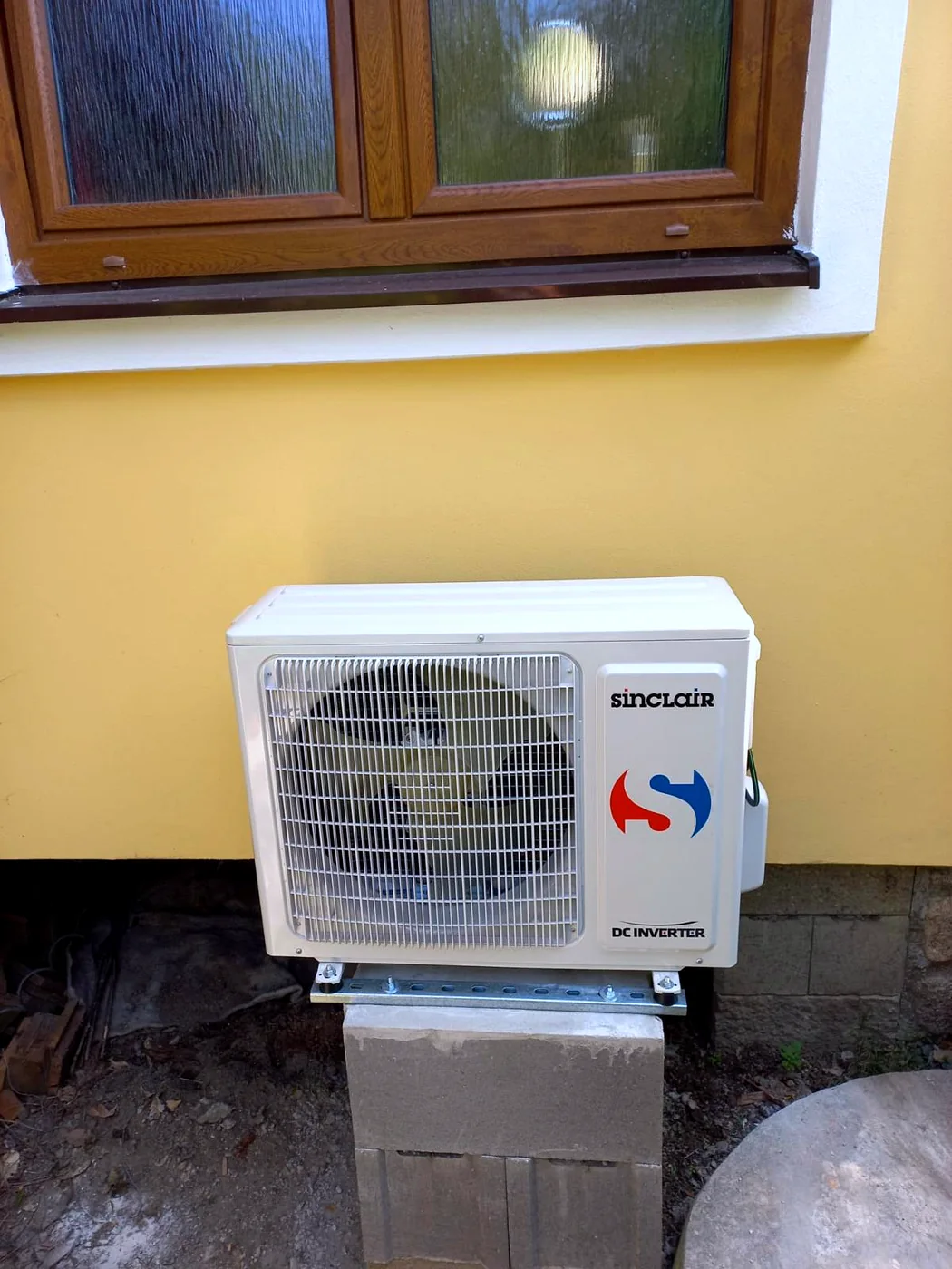 Venkovní jednotka Sinclair DC Inverter pod oknem rodinného domu