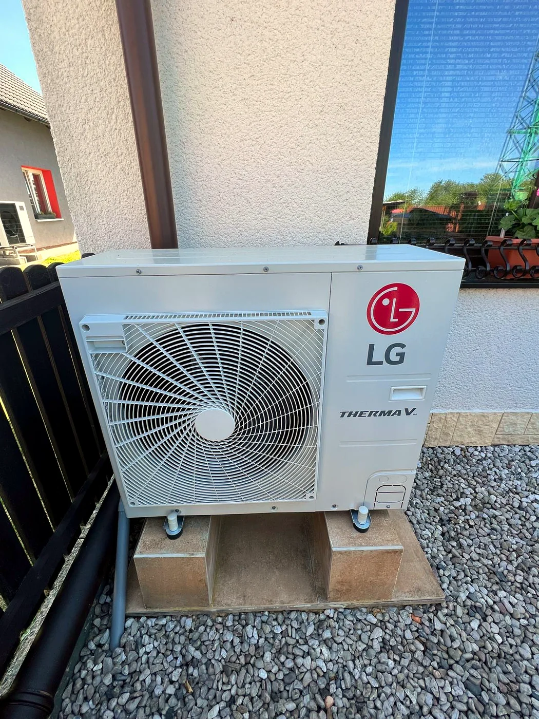 Tepelné čerpadlo LG Therma V na dlážděném podstavci u rodinného domu