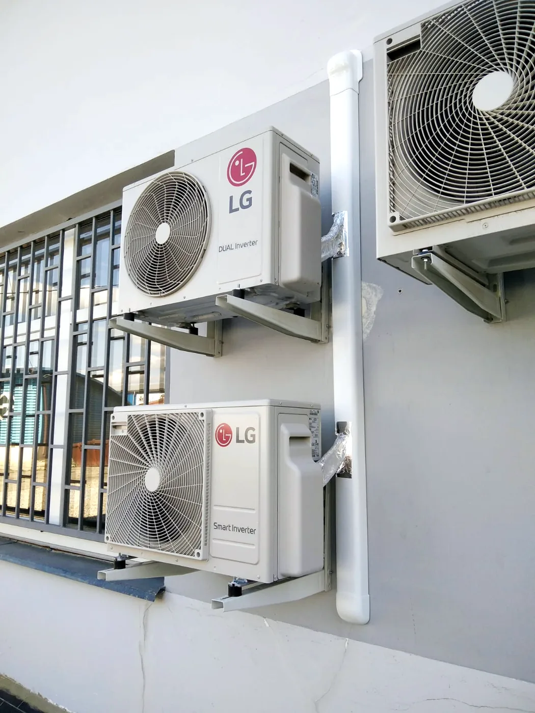 Tři venkovní jednotky klimatizace LG s vedením v krycí liště na fasádě firmy