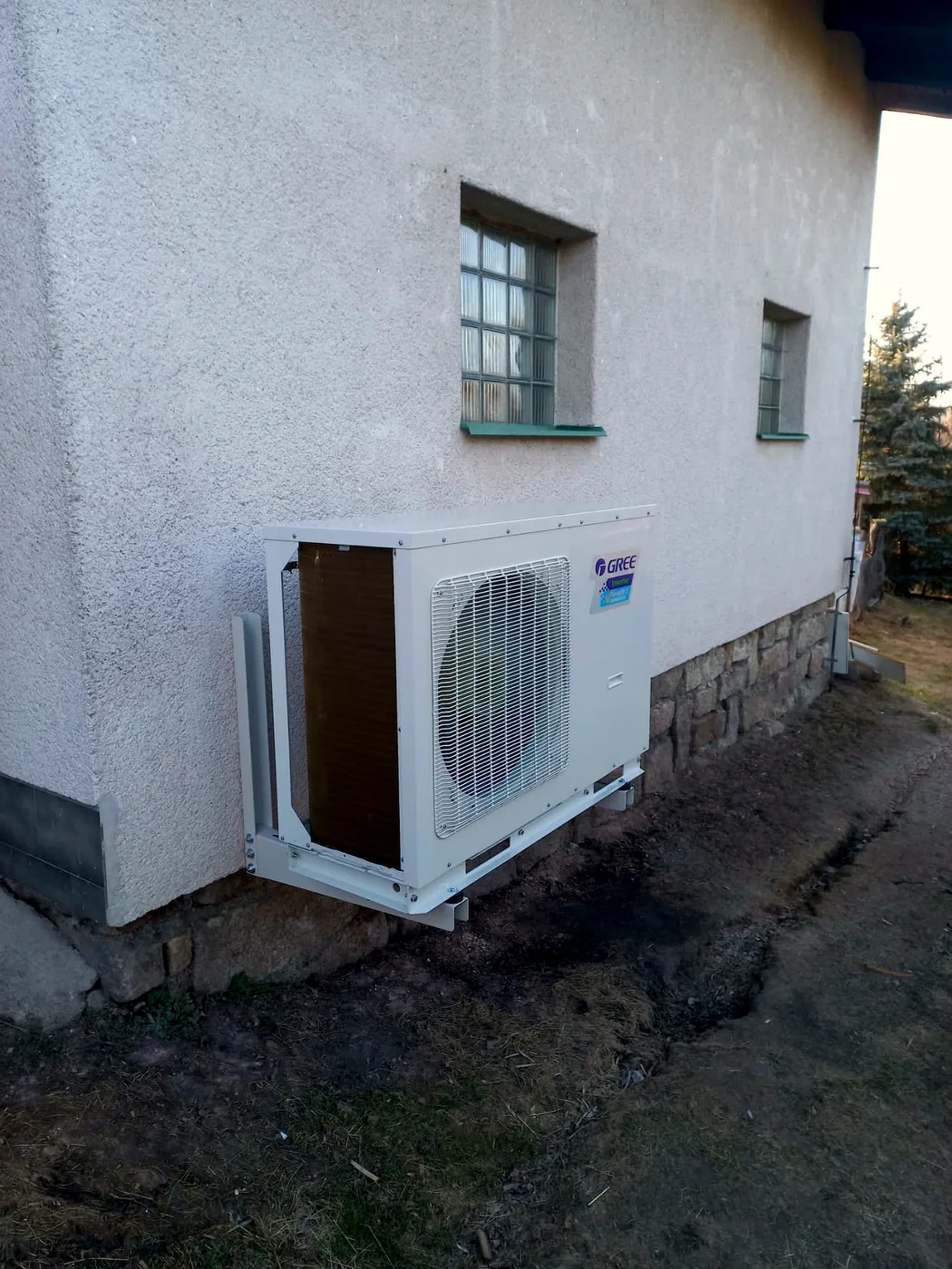 Tepelné čerpadlo Gree na konzolách na fasádě rodinného domu